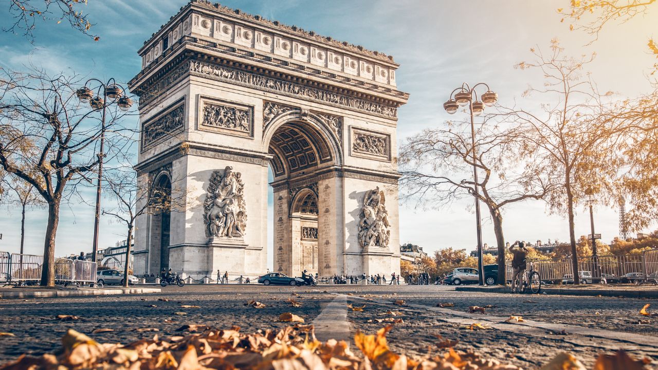 Arc de Triomphe located in Paris, in autumn scenery.