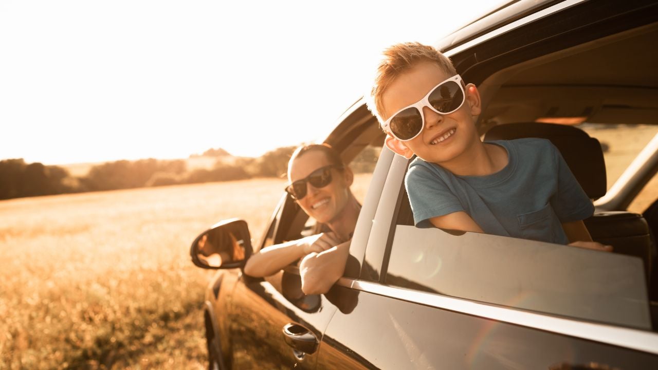 Family road trip. Happy mother and little boy in the car. Family road trip, summer holiday travel.