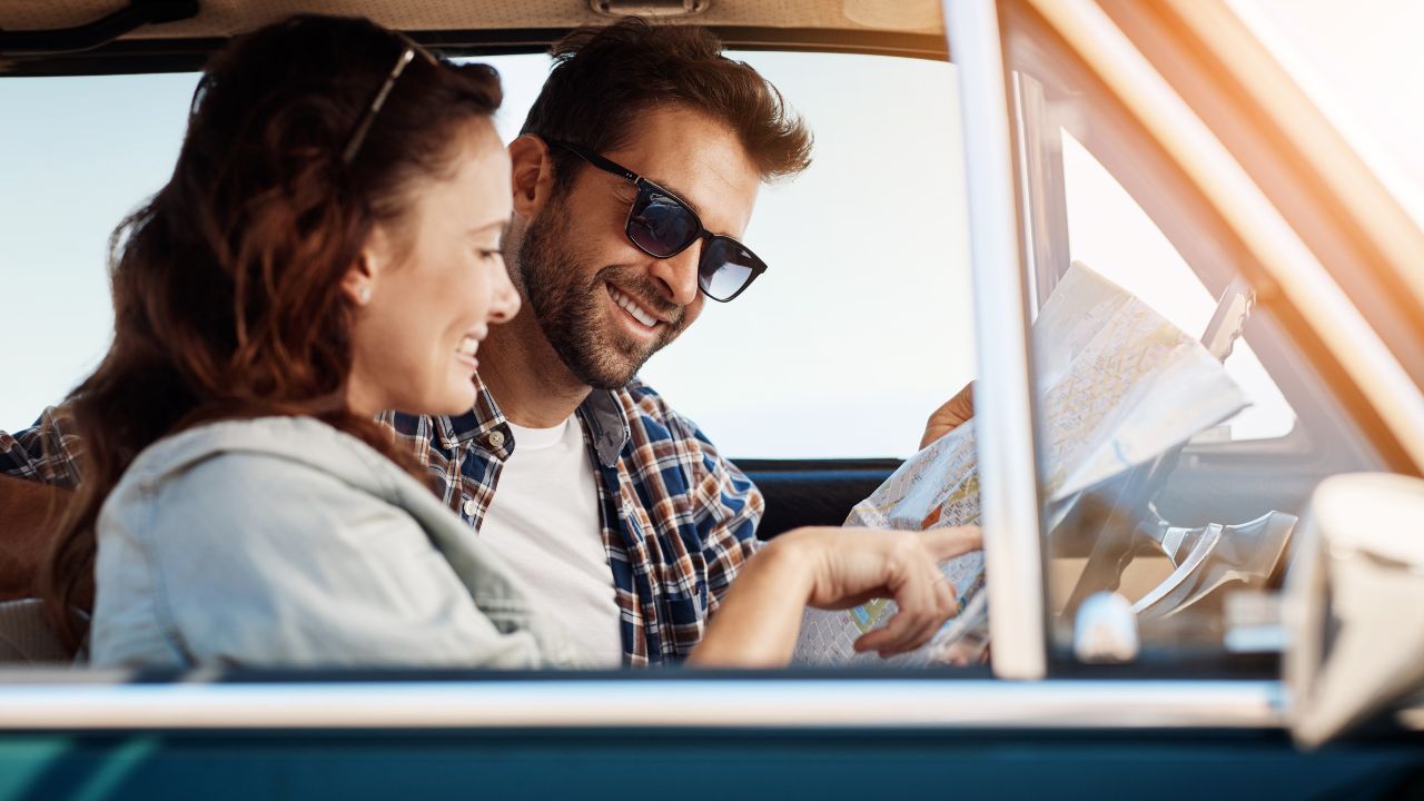 Road trip, couple and map in car for search, location navigation and destination for travel. Happy people, man and woman with paper for guidance, direction and instructions for adventure journey