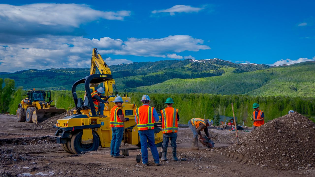 YELLOWSTONE NATIONAL PARK, WYOMING, USA - JUNE 07, 2018: Unidentified people working in a road construction equipment parked in a construction zone. Roadwork in Yellowstone National Park