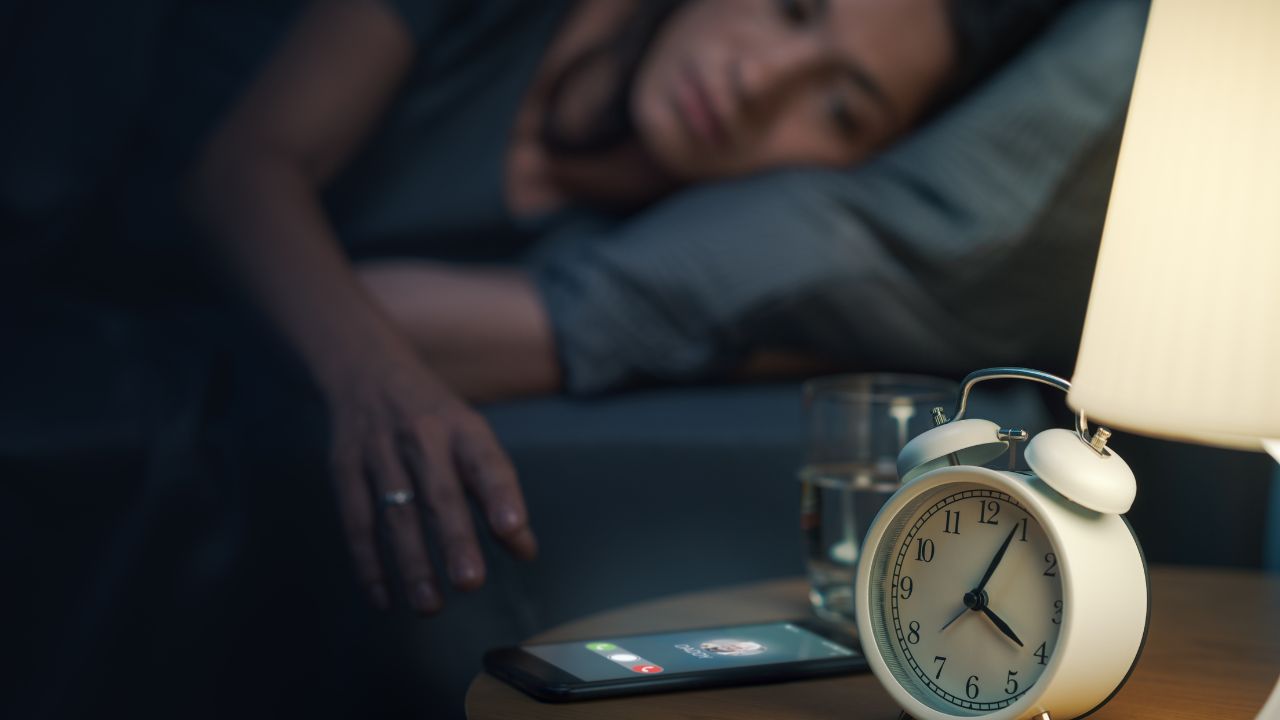 Woman receiving a phone call at night, she wakes up and takes the phone