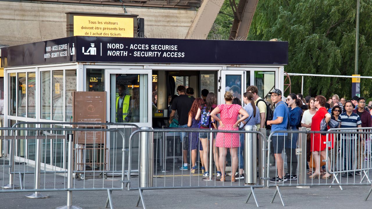 PARIS, FRANCE - JUNE 24, 2017: Unknown people standing in line for control to get into the territory of the Eiffel Tower.