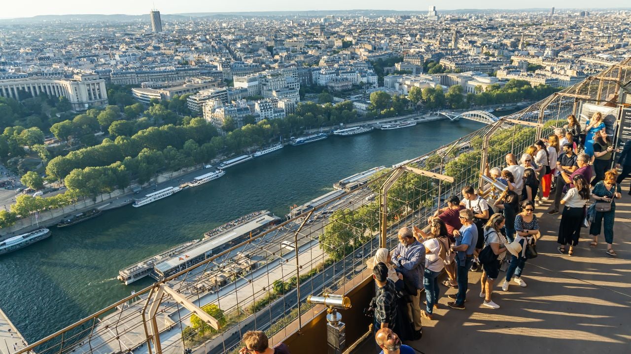 Visitors looking at the Seine and Paris rooftops from the Eiffel Tower