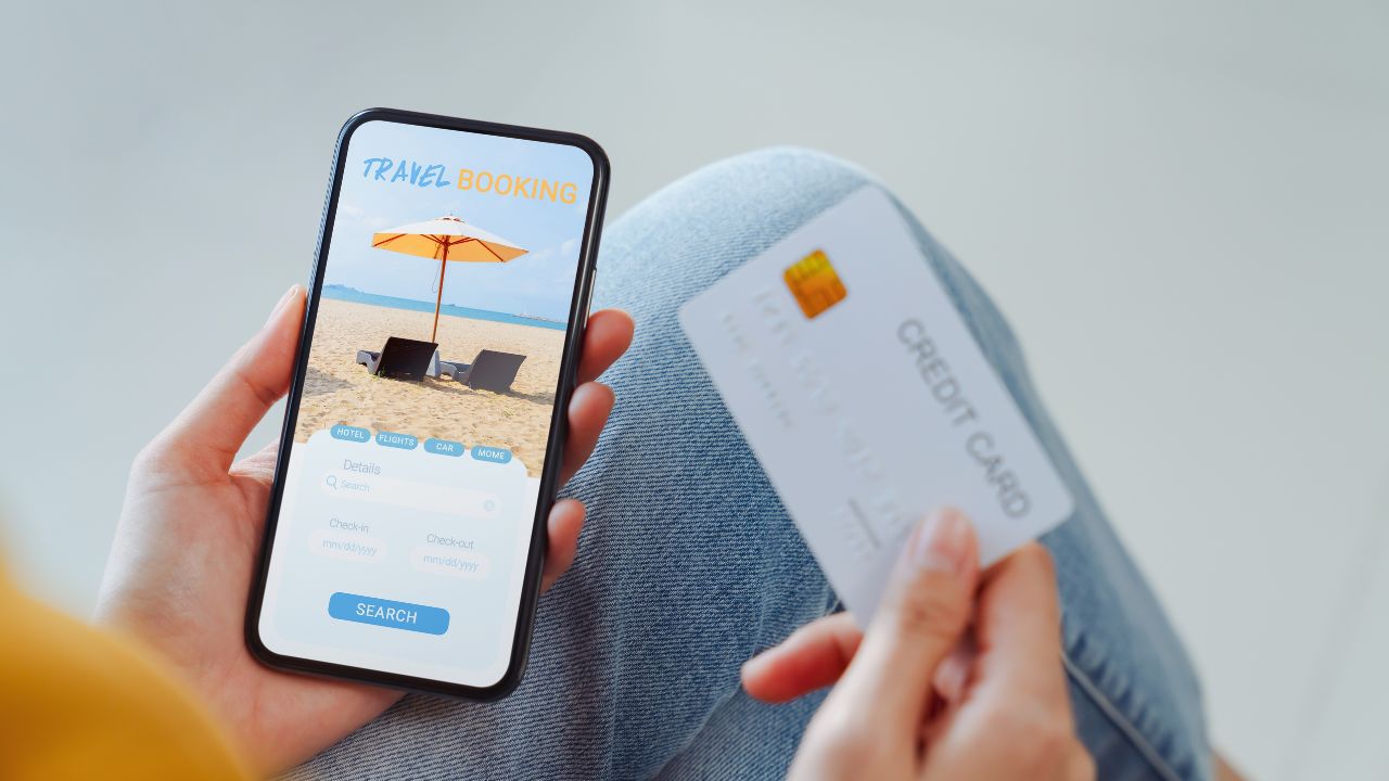 Woman hands using credit card for payment on smartphone with application booking flight travel search ticket holiday and hotel on website.