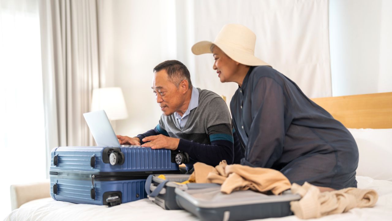 Senior elderly asian couple use laptop for hotel and resort booking online summer holiday travel planning searching information weekend vacation trip.reservation online