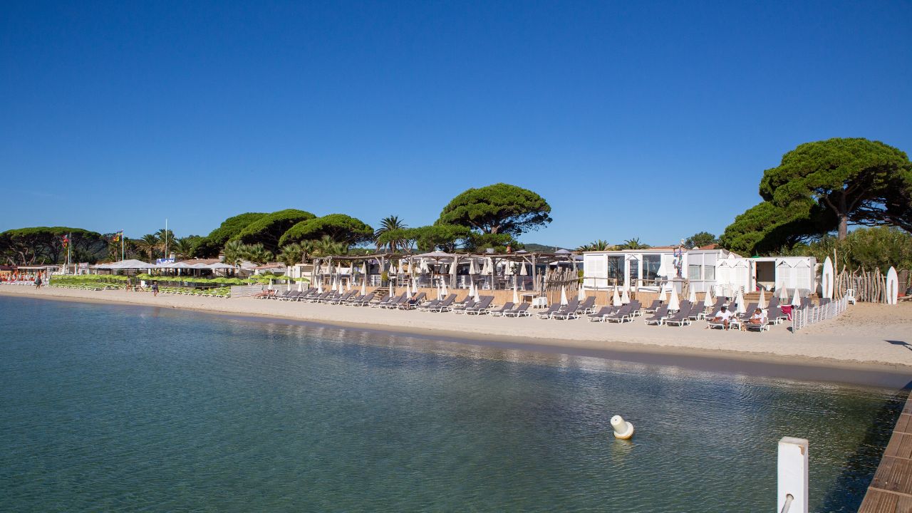Umbrella and sunbathes on Pampelonne private beach, in Ramatuelle, France, Europe; Provence, French Riviera.