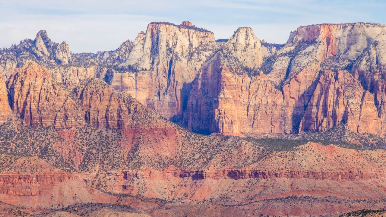 Utah's Zion National Park mountains and canyon close to town of Springdale, La Verkin, and Cedar City, Bryce Canyon, border with Arizona, desert brush, plants, and dark cloudy skies in daylight