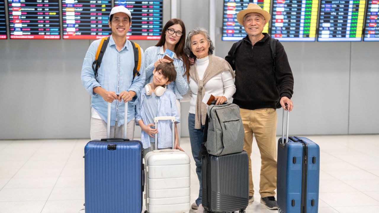 Asian multigenerational family at airport traveling with kids and grandparents, joyful moments of vacation, family holiday trip with luggage before flight, tour, friendly airline, hotel for families