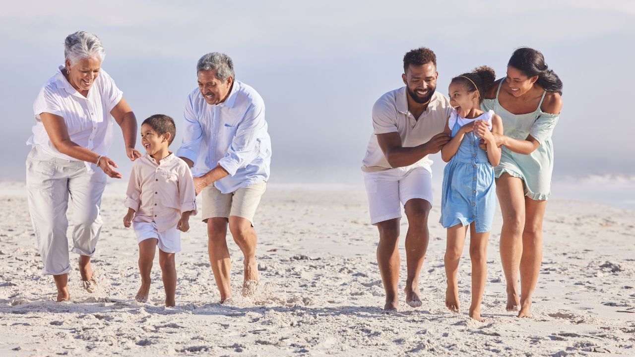 Big family, grandparents or happy kids walking on beach to relax with siblings on fun holiday together. Dad, mom or children love bonding, smiling or playing with senior grandmother or grandfather