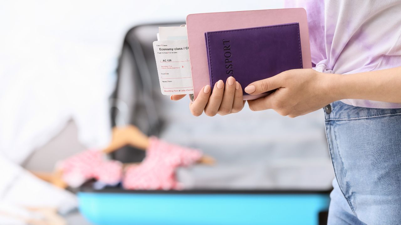 Woman with travel organizer and passport indoors