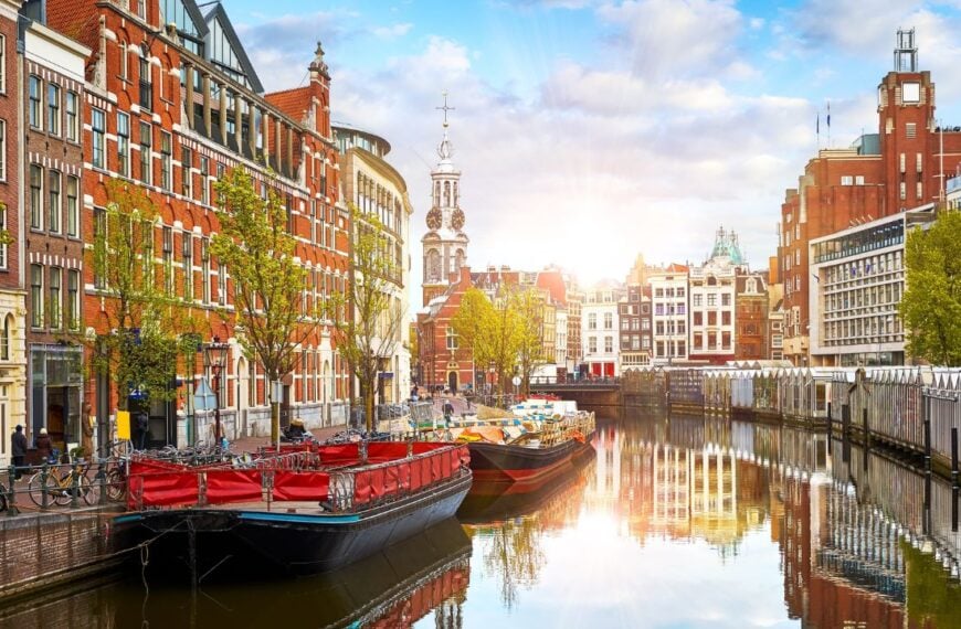Channel in Amsterdam Netherlands. Houses and river Amstel. Famous european landmark. Old city landscape during sunset