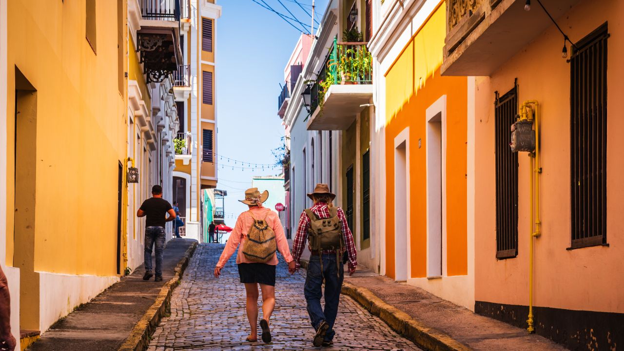San Juan, Puerto Rico - February 27, 2018: Couple walkd hand in hand along colorful colonial architecture in Old San Juan.
