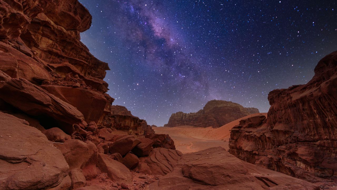 Majestic view of the Wadi Rum desert, Jordan, The Valley of the Moon. Orange sand, Milky Way sky. Copy space night wallpaper. Discover beauty of the earth. National park outdoors landscape