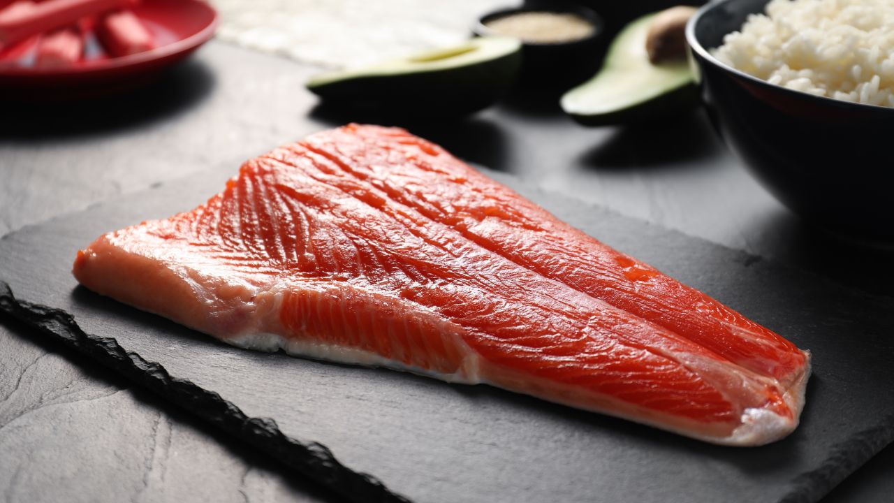 Fresh salmon for sushi on dark table, closeup