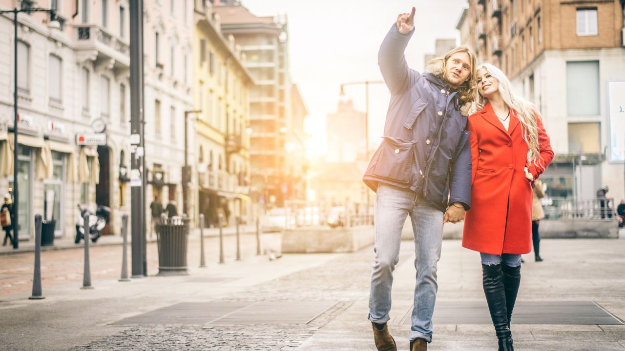 Happy couple walking outdoors on the streets - Two tourists visiting a city - Lovers having a romantic walk