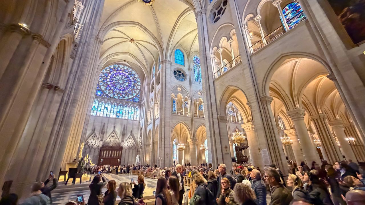 Paris, France - October 11, 2025: Many visitors inside the crossing of Notre Dame cathedral, looking up at the high ceiling vaults and the glow of the rose windows