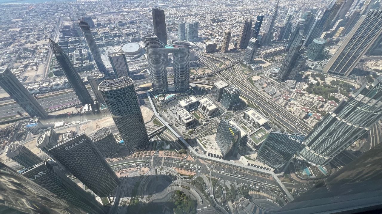 Dubai,United Arab Emirates-March 20th 2026: panoramic view of Dubai skyline with blue skies featuring towering skyscrapers, modern architecture, and vibrant city lights reflecting off tranquil waters.