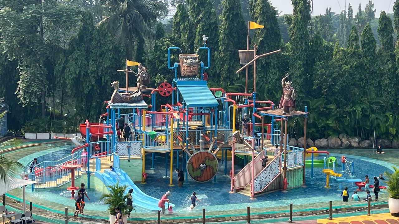 Children and families enjoy a colorful pirate-themed splash zone with slides and interactive water features at a family-friendly waterpark