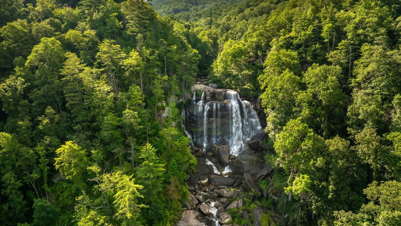 Amazing summer landscape with forest river waters falling down in big waterfall with clear water between rocky boulders in Nantahala National Forest. Whitewater Falls, North Carolina, USA