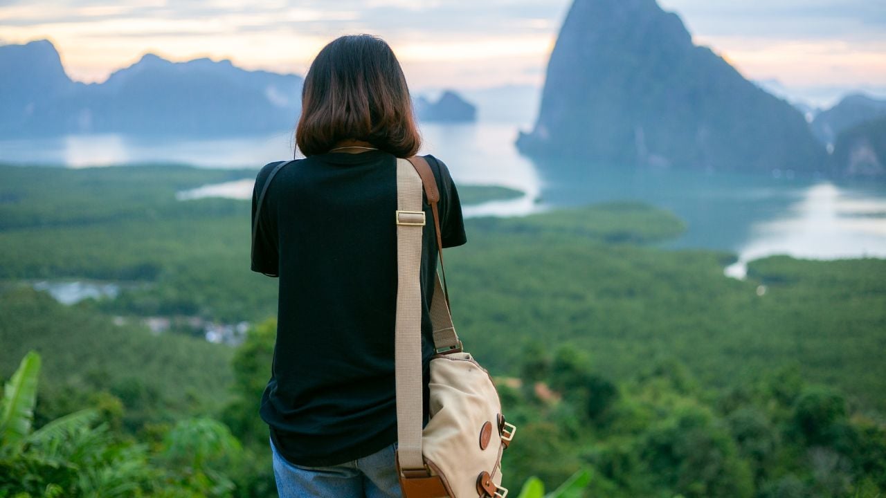Woman traveler taking in mountain and sea views in the morning