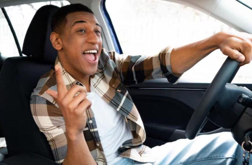 Excited man singing along road trip playlist.