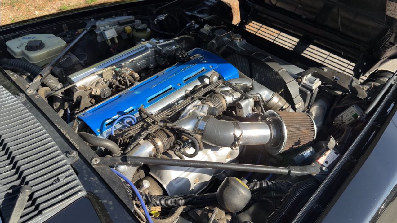 Underhood shot of a 2JZ-swapped 1990 Jaguar XJS featured on Magnacars YouTube Channel with Toyota 2JZ engine in frame