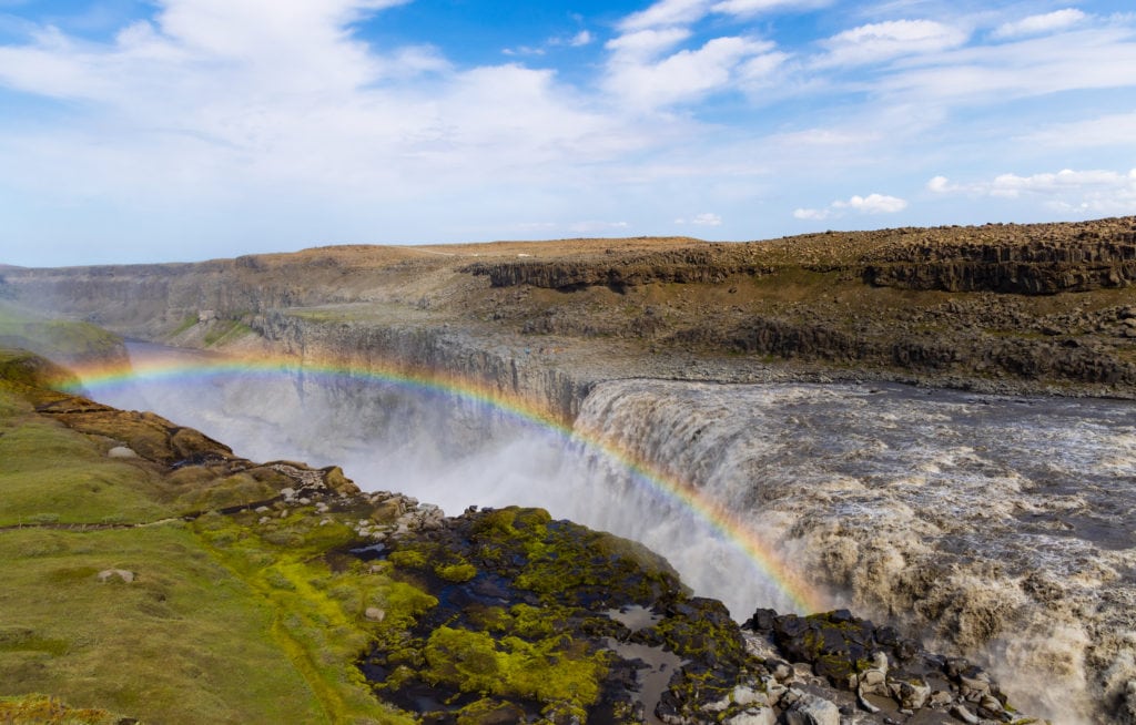 A rainbow is seen in the mist of Dettifoss. This is one of the best things to do in Iceland.