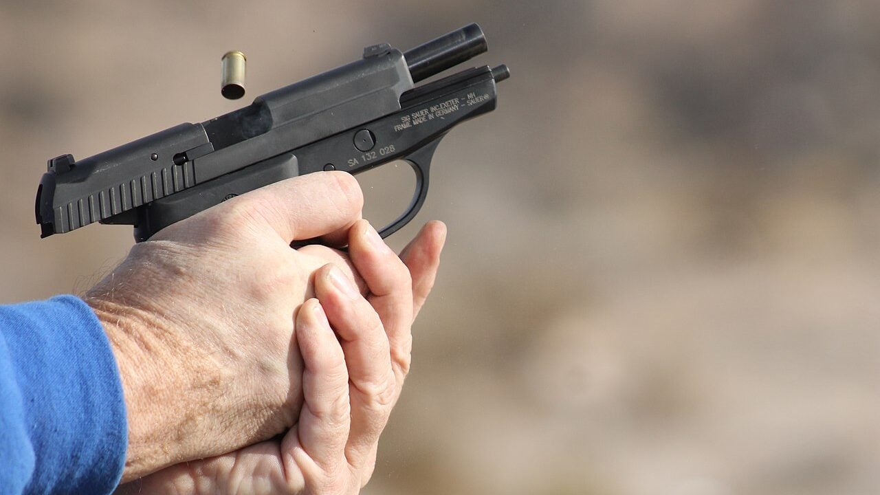A man fires a SIG Sauer P239 at an outdoor shooting range in Nevada.