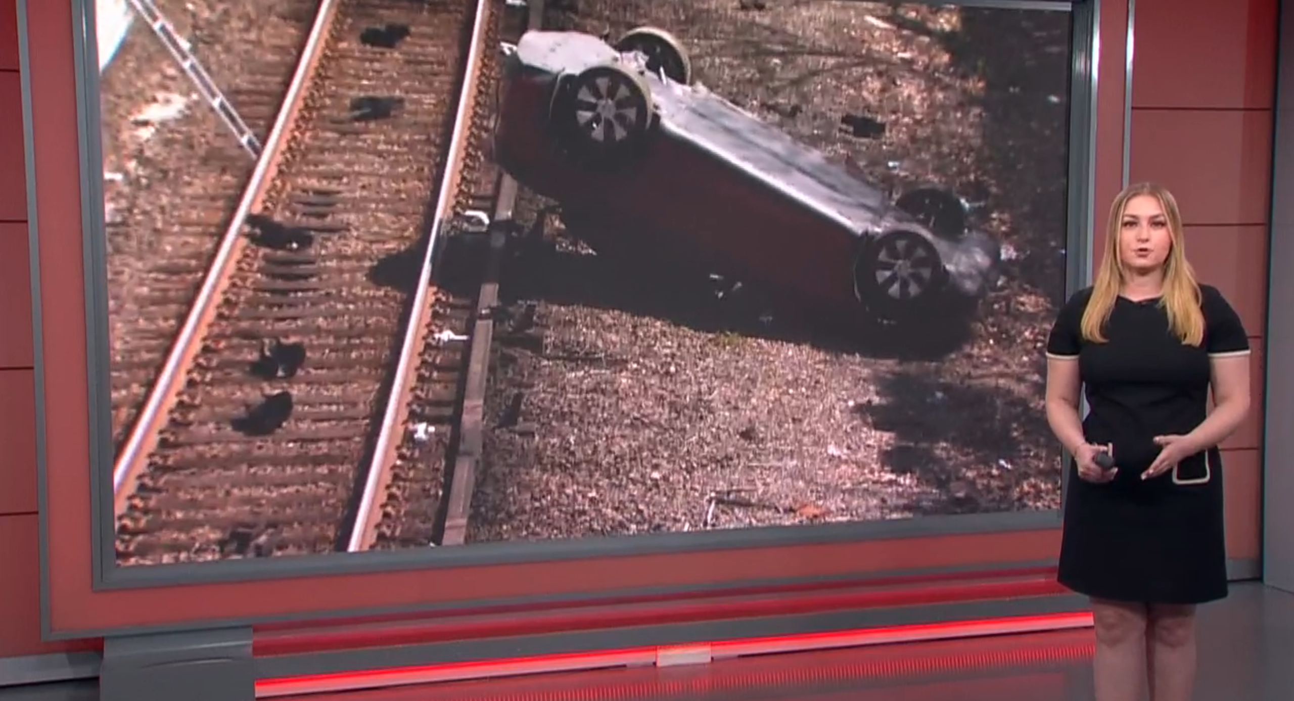 car falls on train tracks
