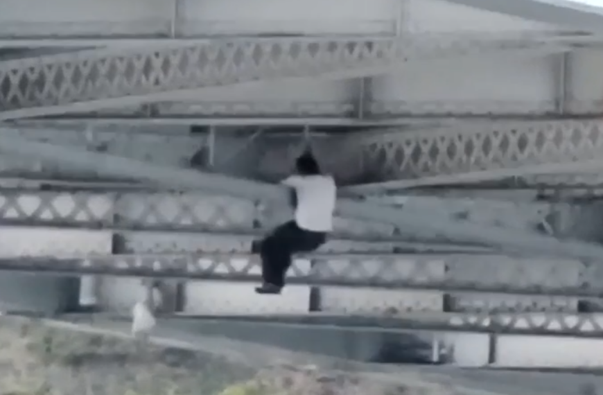 man climbing bridge car chase