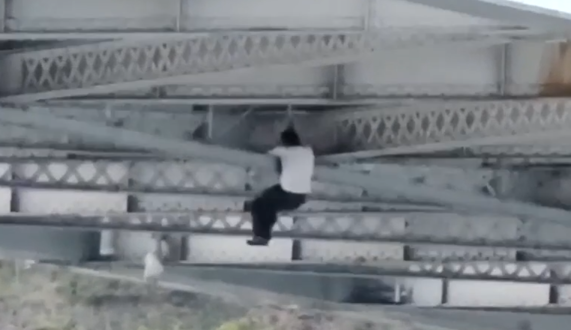 man climbing bridge car chase