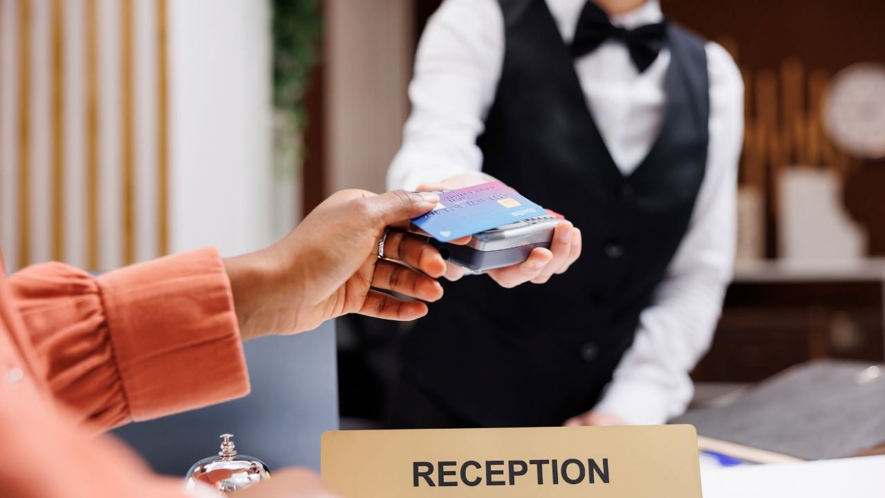 Hotel guest paying by credit card at the front desk