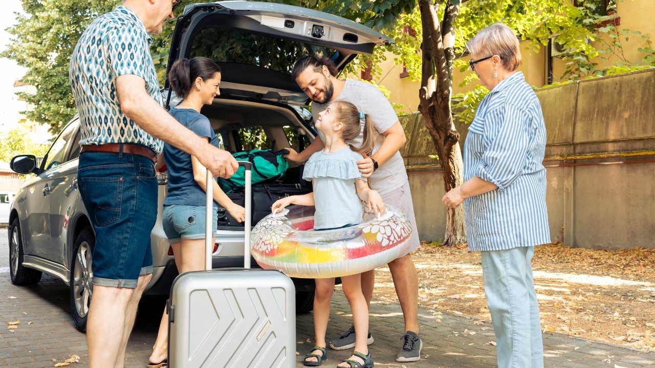 Happy family loading luggage into a car for a vacation trip by the seaside