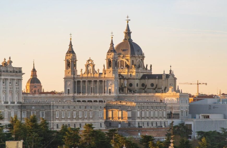 Catedral de Santa Maria la Real de la Almudena, Madrid, Spain, at sunrise, with rooftops of buildings in the foreground
