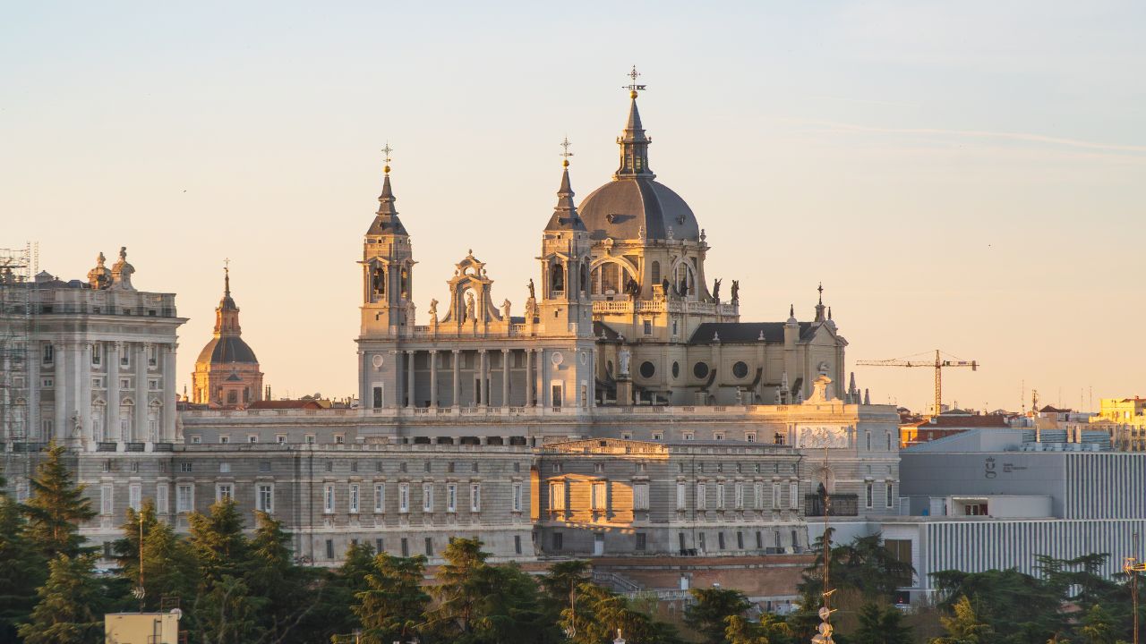 Catedral de Santa Maria la Real de la Almudena, Madrid, Spain, at sunrise, with rooftops of buildings in the foreground
