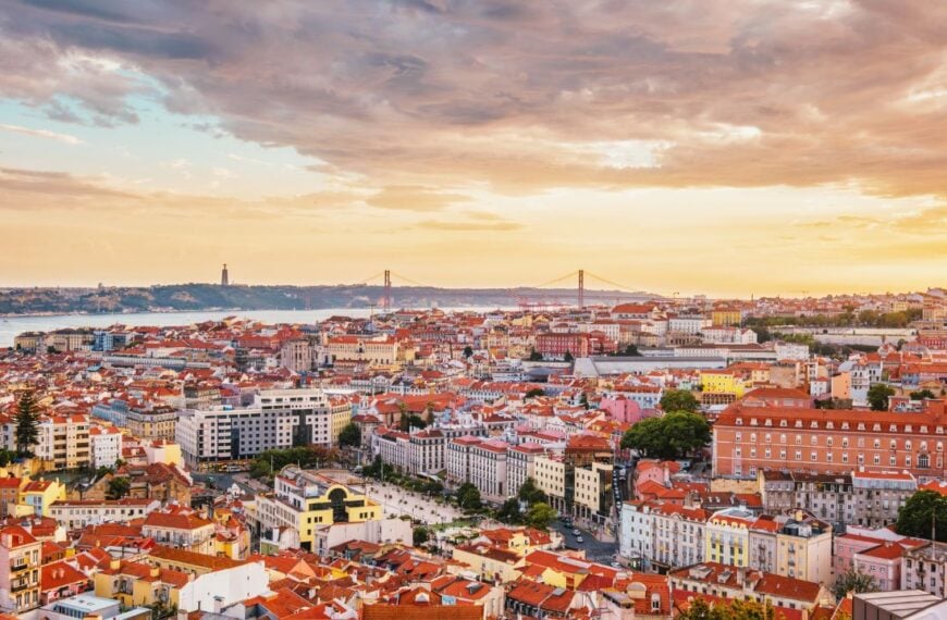 View of Lisbon famous view from Miradouro da Senhora do Monte tourist viewpoint of Alfama and Mauraria old city district, 25th of April Bridge at sunset. Lisbon, Portugal