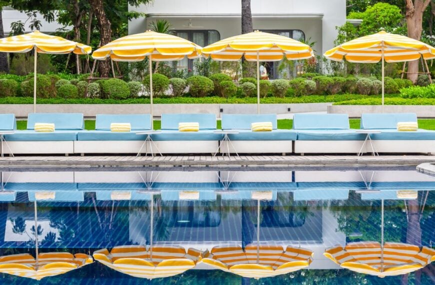 A bright, family-friendly hotel pool with lounge seating and palm-lined surroundings offers a comfortable stay near Disneyland in Anaheim