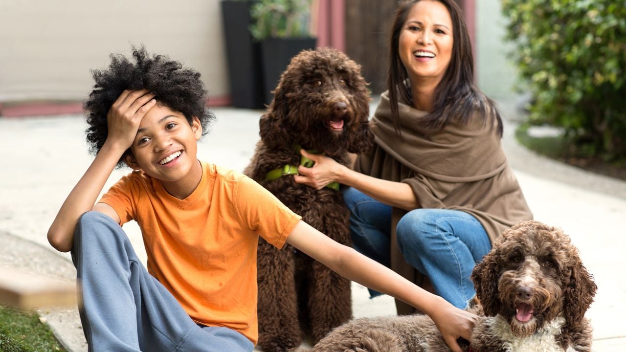 Happy mixed race family playing with their dog.