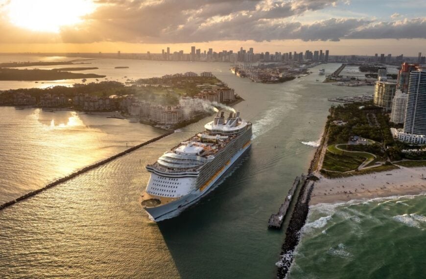 Big passenger cruise liner ship departing at main channel in Miami harbor near South Beach high luxurious hotels and apartment buildings