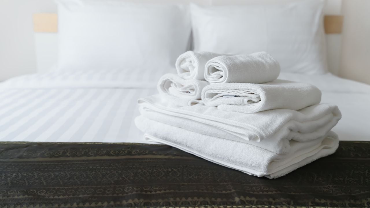 Freshly laundered fluffy towels on bed in hotel