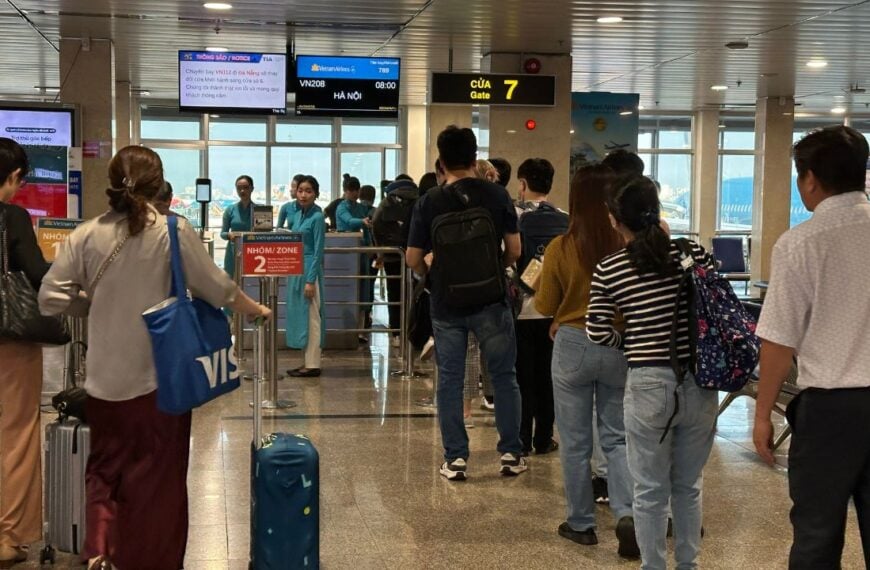 At Vietnam – February 28, 2025: Passengers walk through a busy airport terminal with luggage and carry-on bags. The scene captures the dynamic atmosphere of air travel.