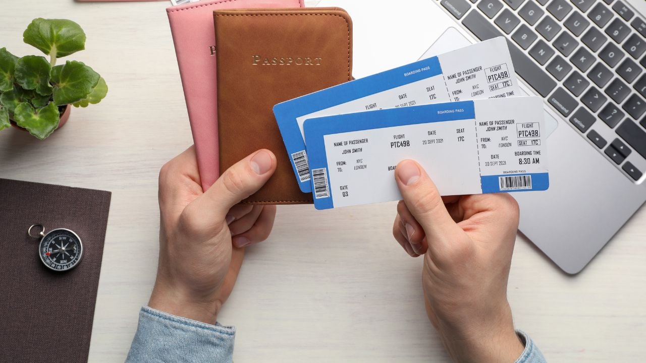 Travel agency. Man with flight tickets and passports at light wooden table, top view