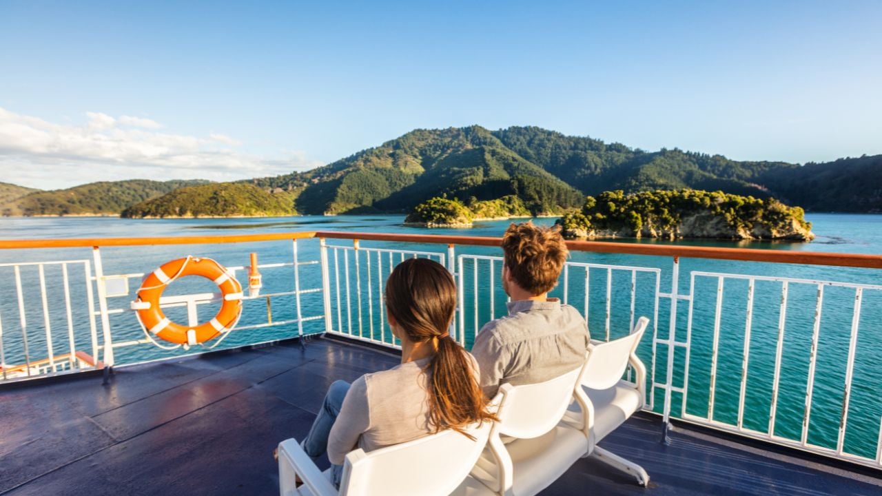 Cruise passengers sitting outside on deck during a scenic sailing