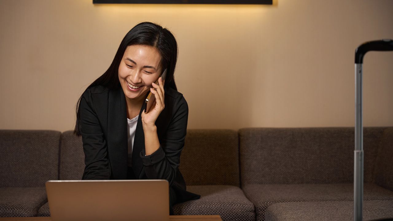 Cute lady communicating on a phone in hotel room