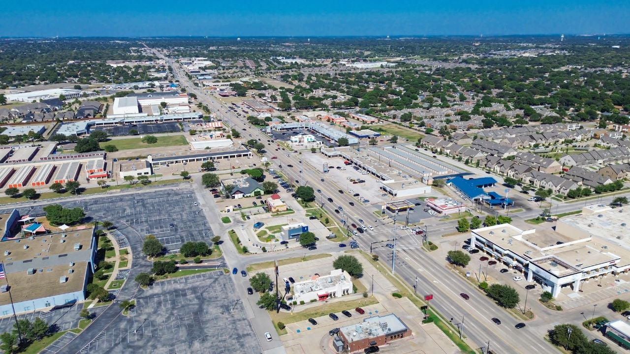 Downtown North Richland Hills, Texas showing freeway-front retail pads, restaurant zones, storage facility, business park, residential neighborhoods with organized street grids and green buffers. USA
