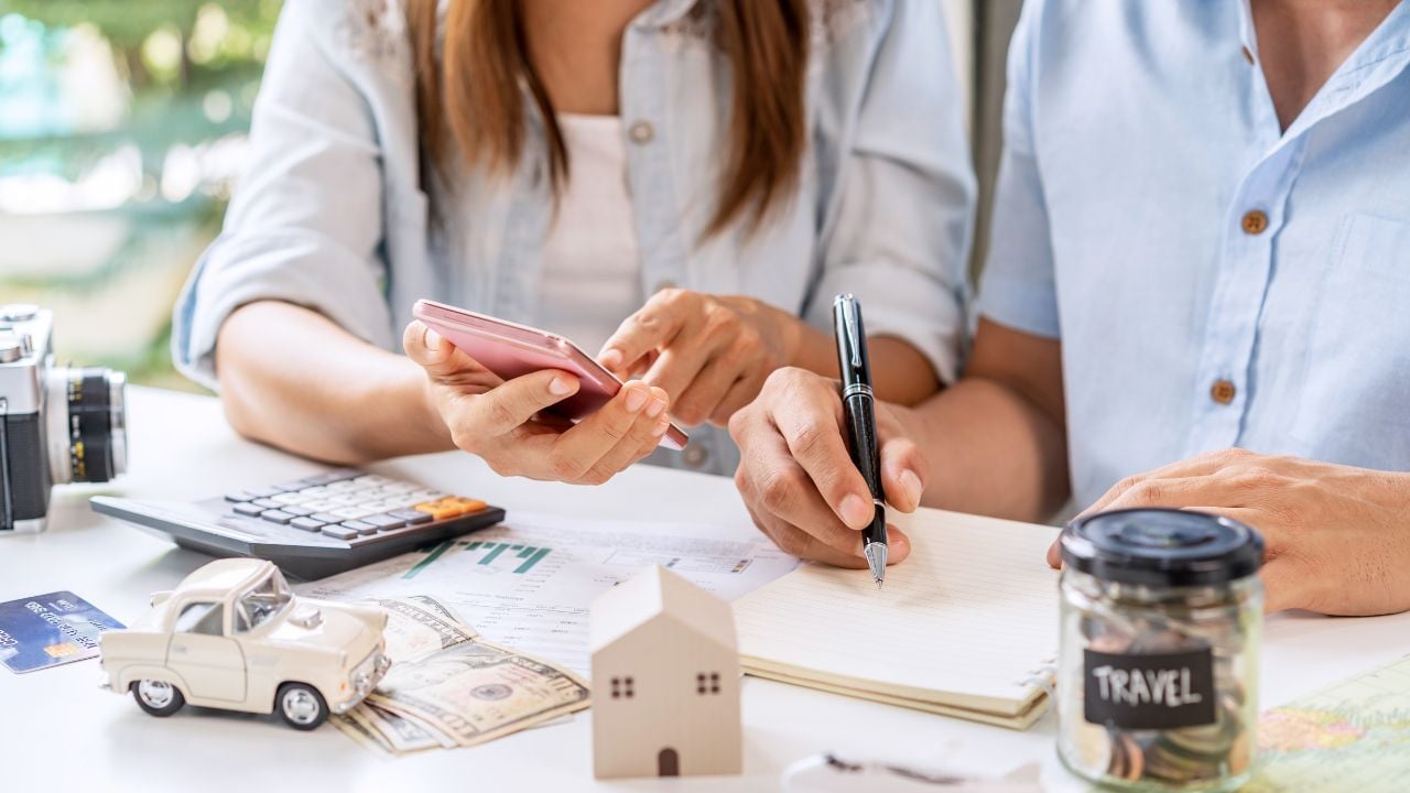 Young couple is planning and managing home expenses (house, car, travel, and credit card) together at home