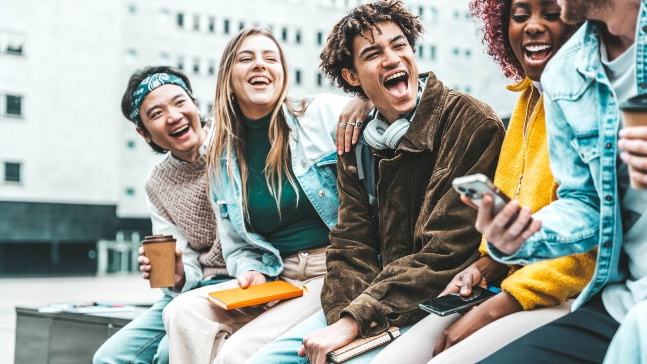Happy group of friends laughing together in a city street