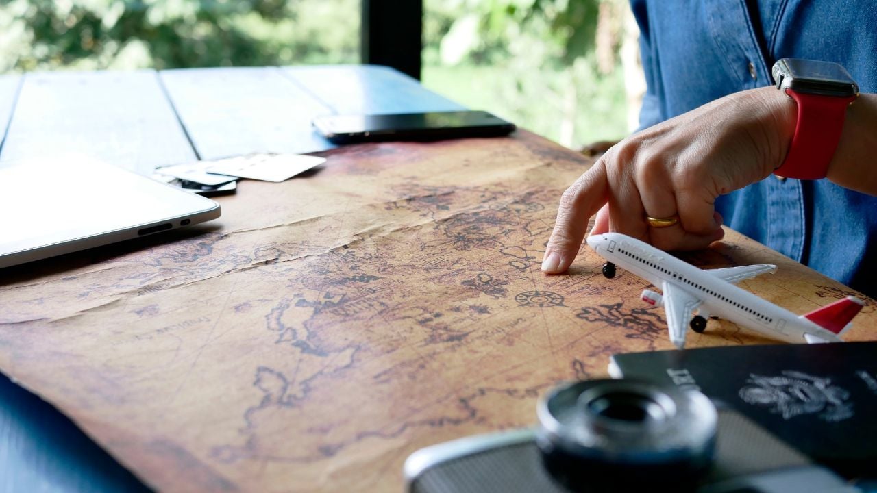 Traveler getting ready for a trip, packing a bag and booking a flight online using a credit card and a tablet.