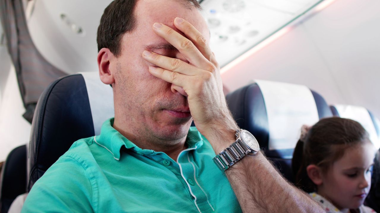 Young man having an anxiety attack on an airplane