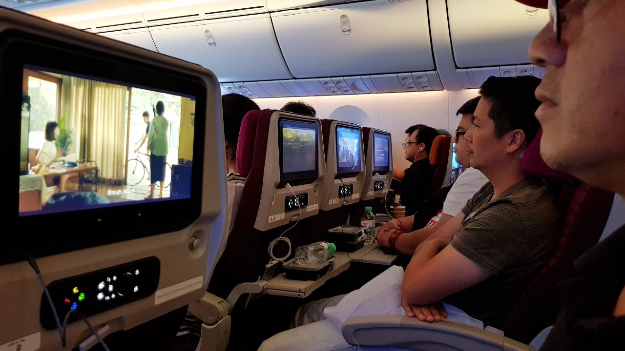 Passengers watching movies on in-flight entertainment screens